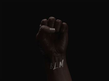 Close-up of human hand over black background