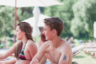 Rear view of shirtless boy looking at water