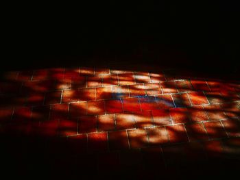 Close-up of illuminated lighting equipment against black background