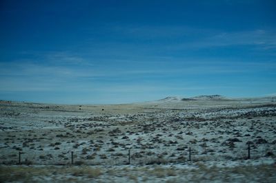 Scenic view of desert against blue sky