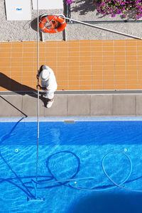 Man standing by swimming pool against wall