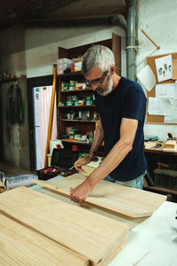 Craftsman working on wooden planks in workshop