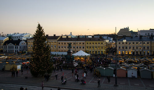 People walking on city street at sunset