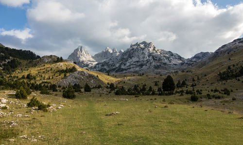 Scenic view of field and mountains against sky