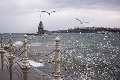 Railing on pier by splashed sea water