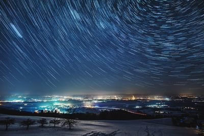 Illuminated city against sky at night