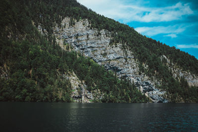 Scenic view of river by mountains against sky