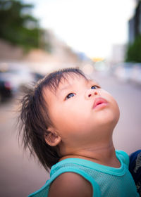 Close-up of girl looking up on street