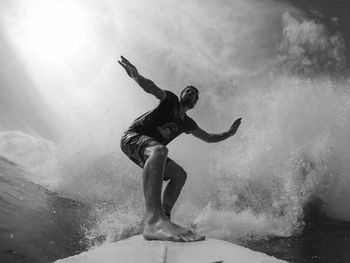 Man surfing on sea against sky