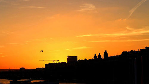 Silhouette buildings against sky during sunset