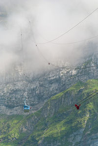 Overhead cable car over mountain against sky