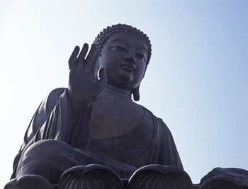 Low angle view of tian tan buddha against sky