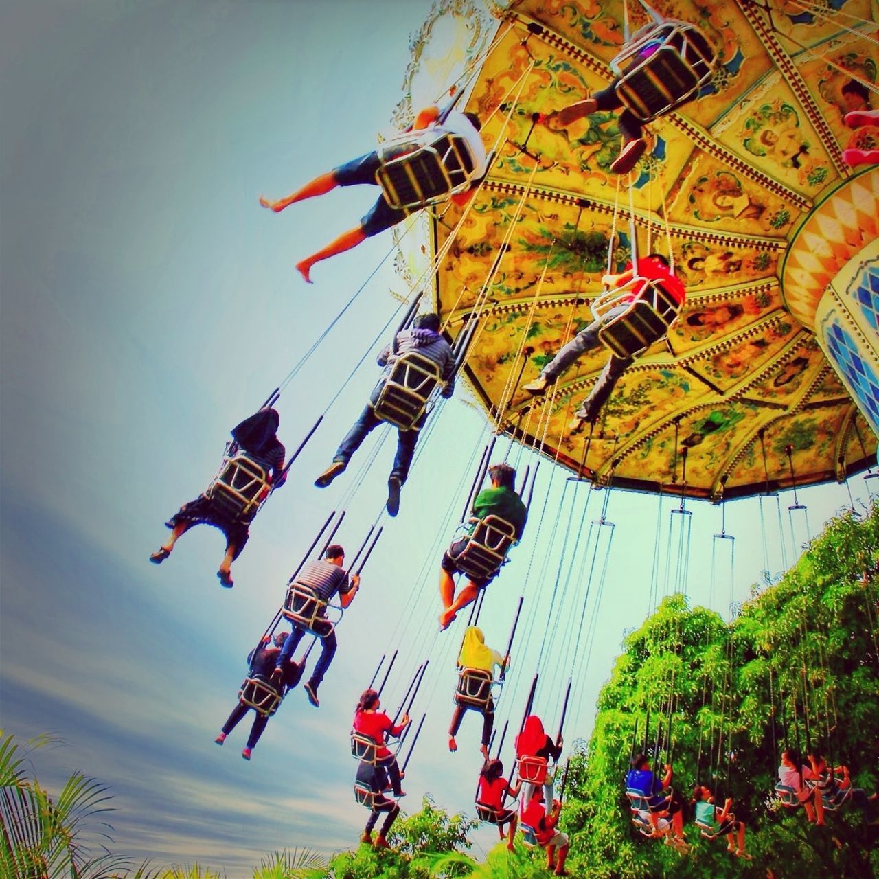 low angle view, tree, flag, arts culture and entertainment, amusement park, amusement park ride, sky, patriotism, identity, multi colored, clear sky, day, built structure, outdoors, national flag, american flag, architecture, growth, travel, travel destinations