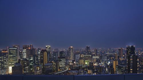 Illuminated cityscape against clear sky