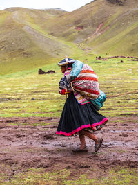 Woman with umbrella walking on field