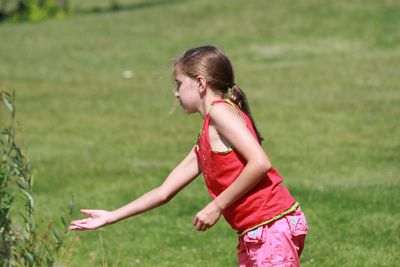 Side view of girl standing on field