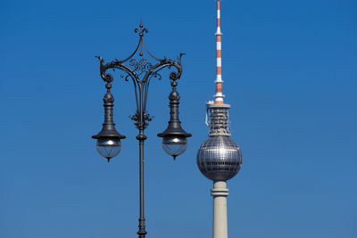 Low angle view of communications tower against sky in city