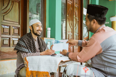 Young man doing charitable donation at mosque