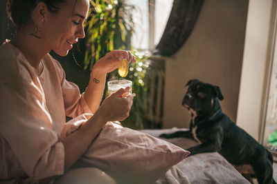 Woman holding dog sitting at home