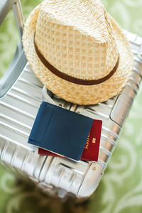 High angle view of hat and passport on luggage