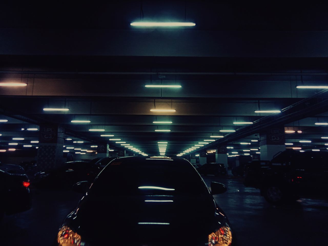 illuminated, transportation, mode of transportation, architecture, land vehicle, lighting equipment, motor vehicle, car, real people, night, indoors, incidental people, travel, built structure, city, light, in a row, sign, lifestyles, ceiling