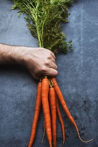 Cropped hand of man holding carrot