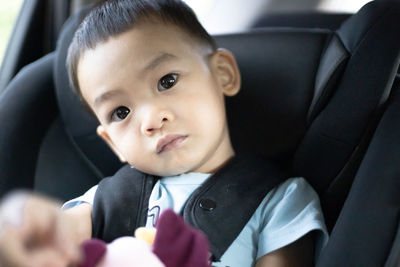 Portrait of cute boy sitting in car