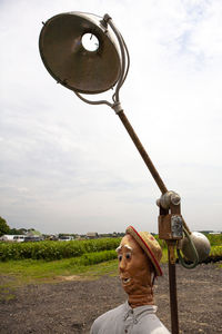 Portrait of man standing on metal against sky
