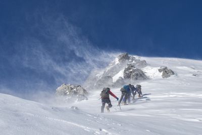 Mountain hiking on the cold snow while trailing the track walk