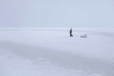 Man on shore against clear sky