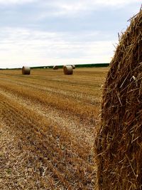 Hay bales on field against sky