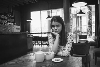 Portrait of young woman sitting in restaurant