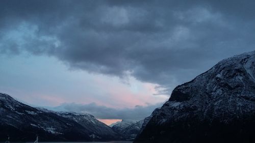 Snow covered mountains against cloudy sky