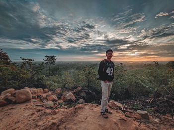 Full length of young man standing on rock