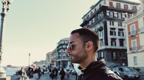 Portrait of man looking at city against sky