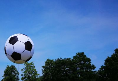 Low angle view of soccer ball against blue sky