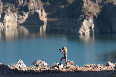 Man standing on rock by lake