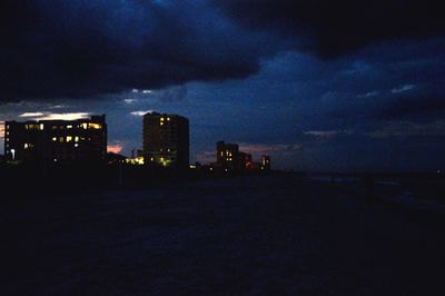 Illuminated buildings against sky at night