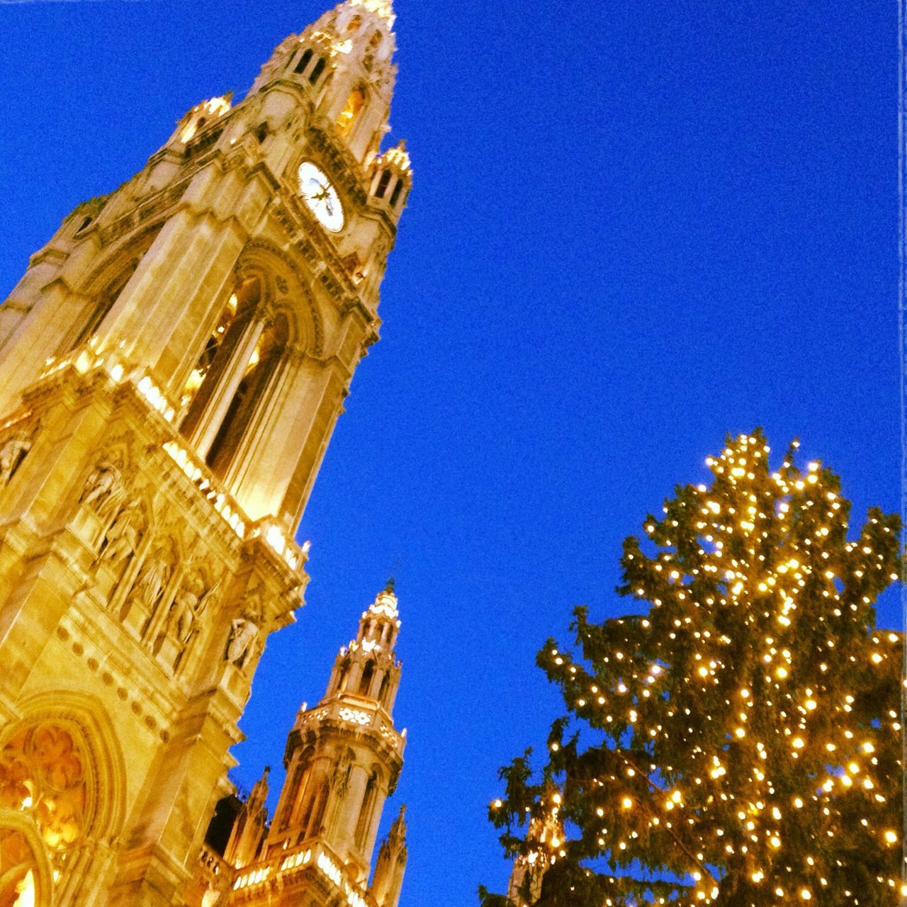 low angle view, blue, clear sky, architecture, building exterior, built structure, illuminated, famous place, copy space, sculpture, travel destinations, art and craft, statue, art, gold colored, international landmark, religion, tourism, travel, night