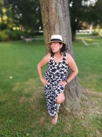 Full length of boy on tree trunk in field