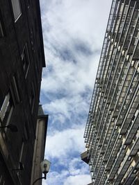 Low angle view of buildings against cloudy sky