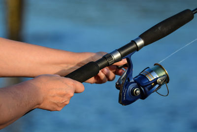 Close-up of hand holding camera against blurred background