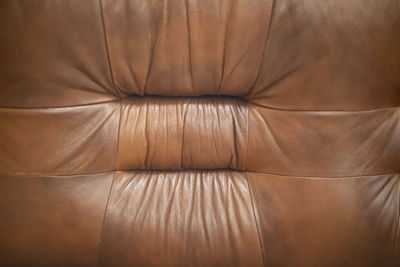 Leather sofa of brown color. furniture details. place to relax in apartment. old sofa.