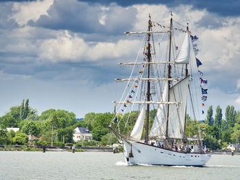 Sailboats sailing in sea against sky