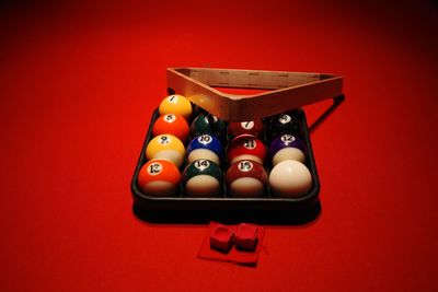 High angle view of multi colored balls on red background