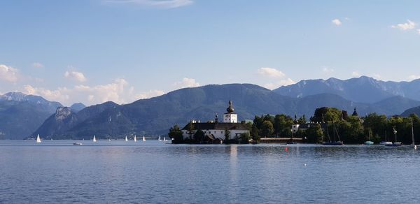 Scenic view of building by mountain against sky