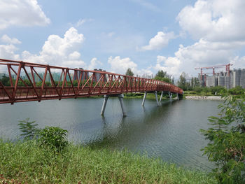 Bridge over river against cloudy sky