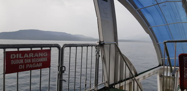 View of sign on sea against sky