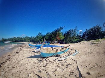 Scenic view of beach against clear blue sky