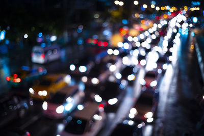 Defocused image of illuminated lights on road at night